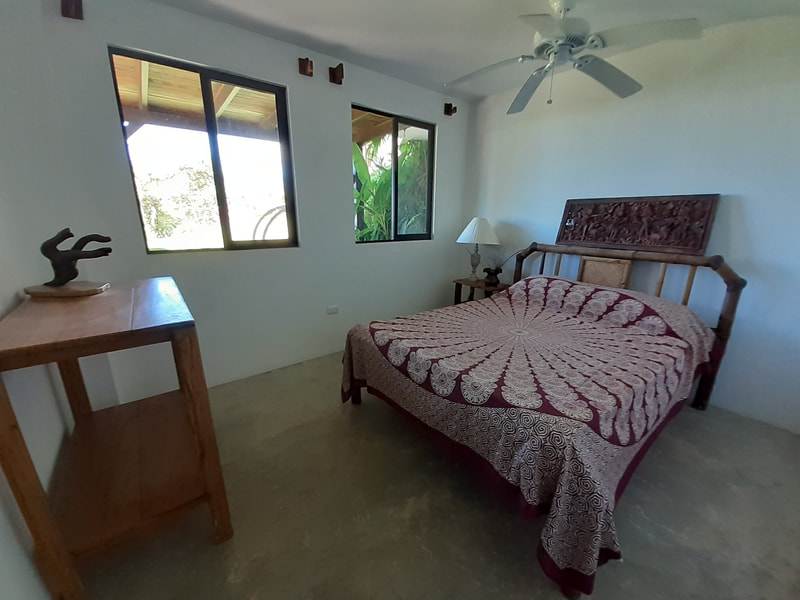 Rooms are simple and clean. This room has cement walls and is set into the ground so it does remain cool. There is a ceiling fan. Screens on all windows and doors so you can let in the ocean breeze.